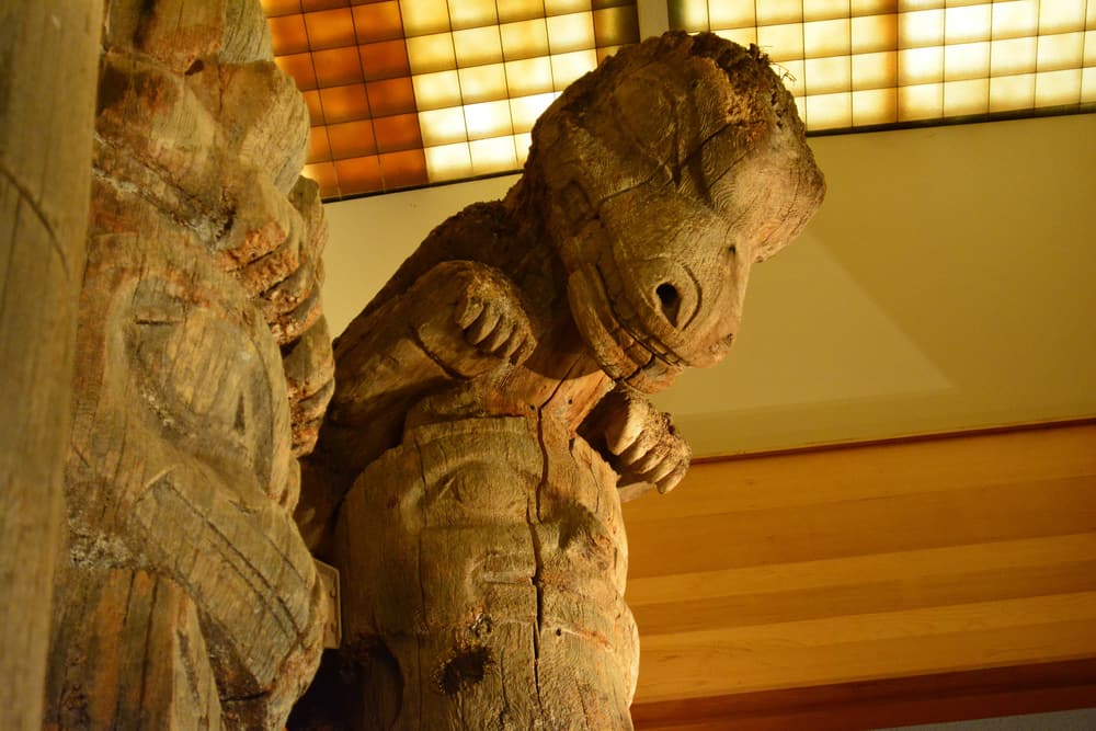 A weathered original totem pole inside the Totem Heritage Center